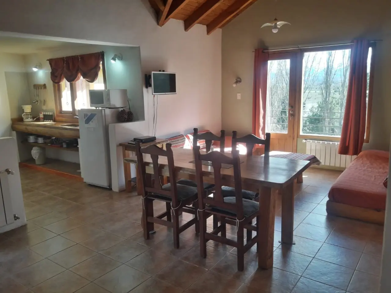 Living comedor con la cocina integrada y techo de madera